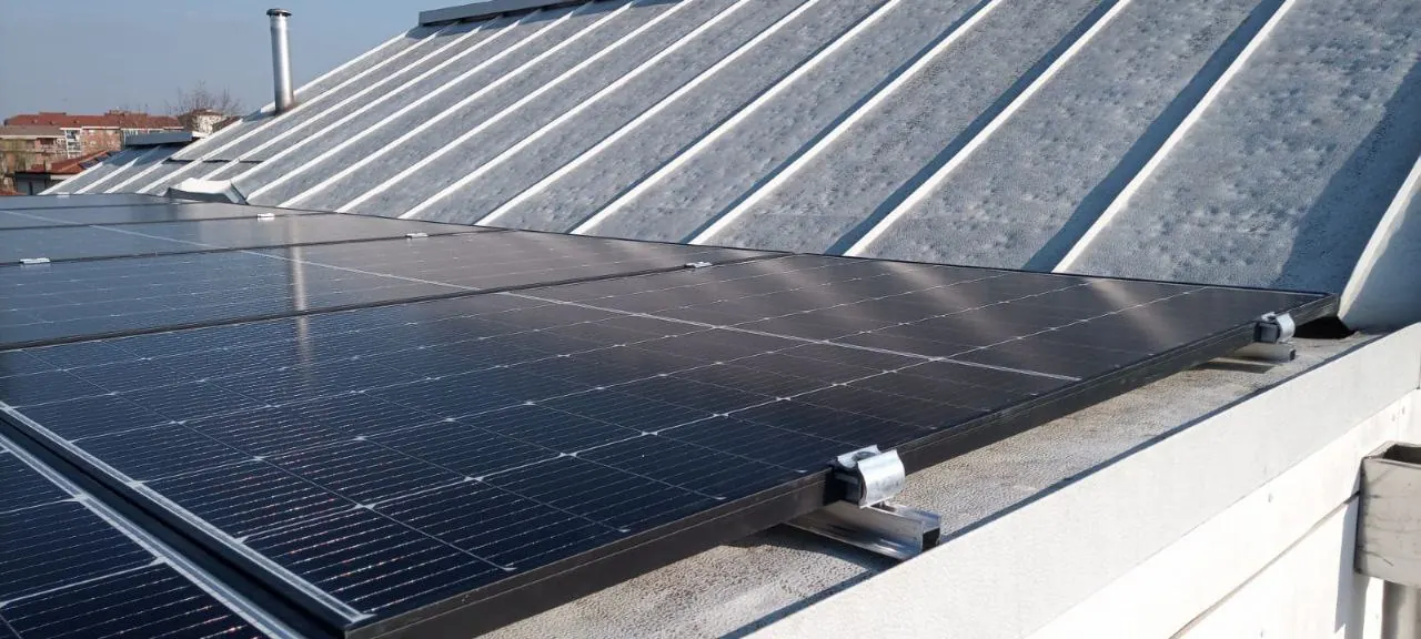 Particolare del fissaggio con morsetto di un modulo fotovoltaico sulla copertura metallica nervata