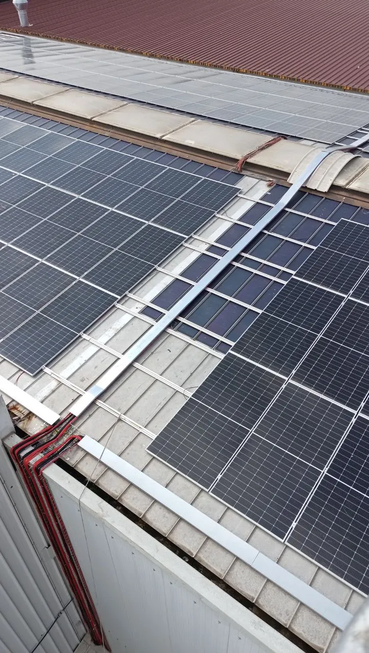 Particolare dei moduli fotovoltaici e dei profili di sostegno ai bordi del tetto di un capannone industriale