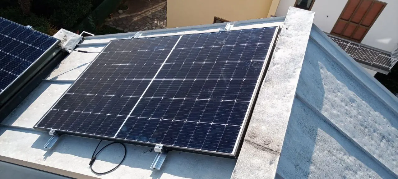 Modulo fotovoltaico con il cavo di collegamento visibile, fissato su una copertura metallica chiara